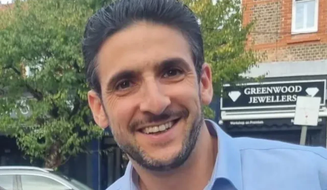 Yoni Finlay, smiling at the camera in a blue shirt