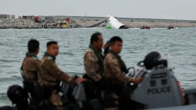 Police on a boat inspecting the cargo plane