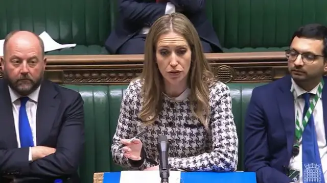 Laura Trott in patterned cardigan speaking at Commons