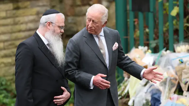 King Charles with Rabbi Daniel Walker looking at flowers from well wishers