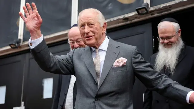King Charles waves at the crowd gathered to see him in Manchester