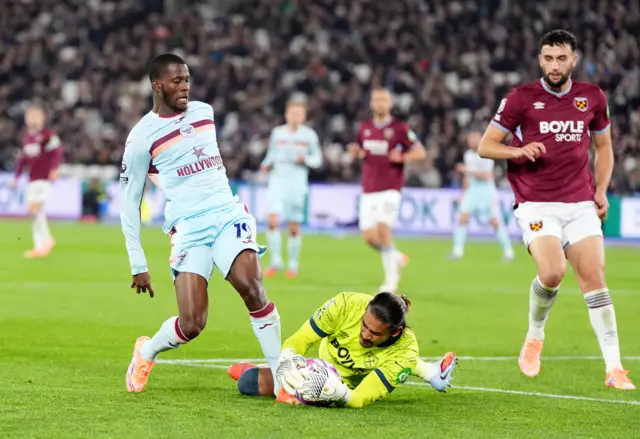 Brentford's Dango Ouattara and West Ham United goalkeeper Alphonse Areola battle for the ball during the Premier League match at London Stadium, London.
