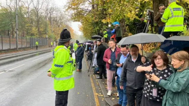 Police officers standing by the crowds of well wishers