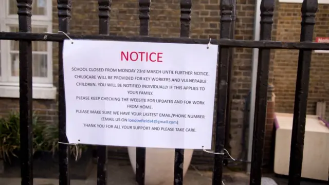 Sign that says: NOTICE SCHOOL CLOSED FROM MONDAY 23 MARCH UNTIL FURTHER NOTICE CHILDCARE WILL WE PROVIDED FOR KEY WORKERS AND VULNERABLE CHILDREN, YOU WILL BE NOTIFIED INDIVIDUALLY IF THIS APPLIES TO YOUR FAMILY PLEASE KEEP CHECKING THE WEBSITE FOR UPDATES AND FOR WORE FROM HOME PLEASE MAKE SURE WE HAVE YOUR LASTEST EMAIL/PHONE NUMBER (EMAIL US ON THANK YOU FOR ALL YOUR SUPPORT AND PLEASE TAKE CARE