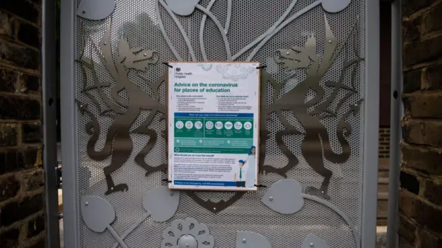 sign on an entrance gate indicates advice on coronavirus at schools at the temporarily closed primary school in England