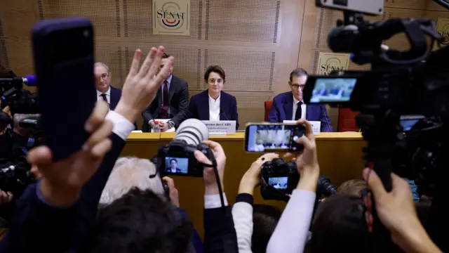 The president and director of the Louvre, Laurence des Cars, faces a press pack