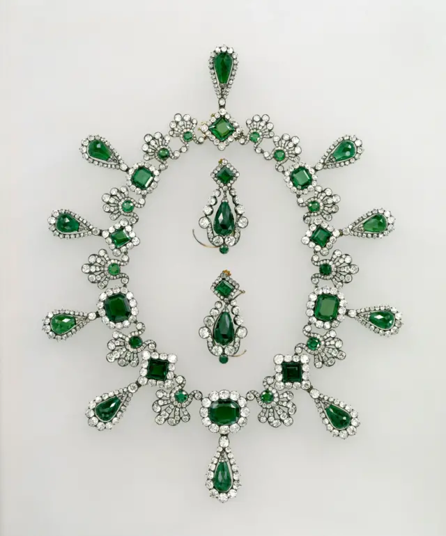 An emerald necklace and earrings with diamonds