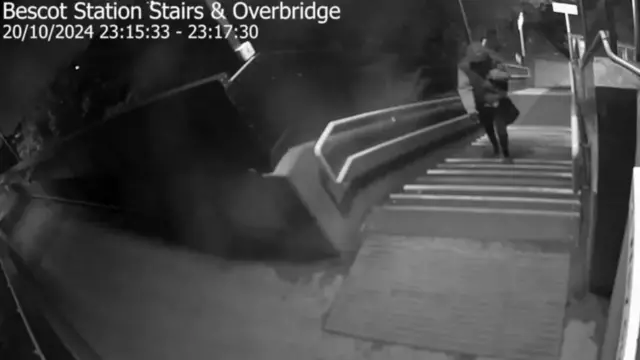 A figure in a grey top on steps leading upwards at Bescot Stadium station