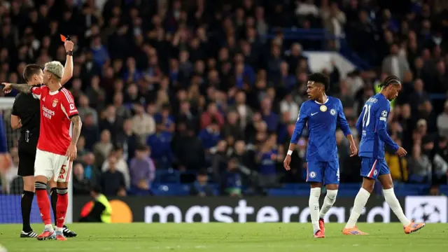 Daniel Siebert shows a red card to Joao Pedro of Chelsea