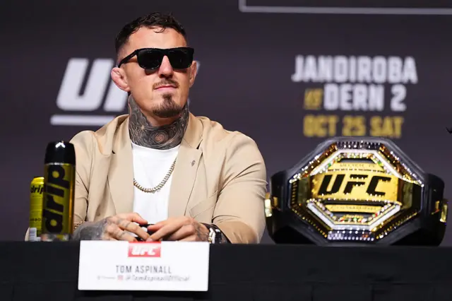 Tom Aspinall in sunglasses at a news conference