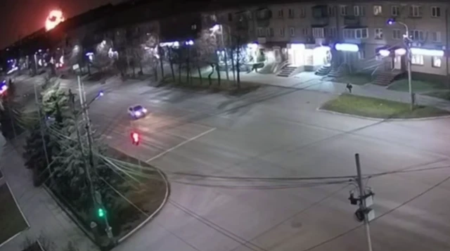 A CCTV video of a road a large fireball is visible in the top left corner of the frame