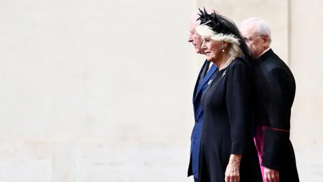 King Charles and Queen Camilla stand on ceremony as the national anthem plays