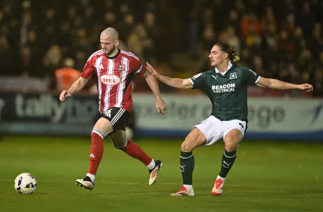 Pierce Sweeney of Exeter City battles for possession with Lorent Tolaj of Plymouth Argyle