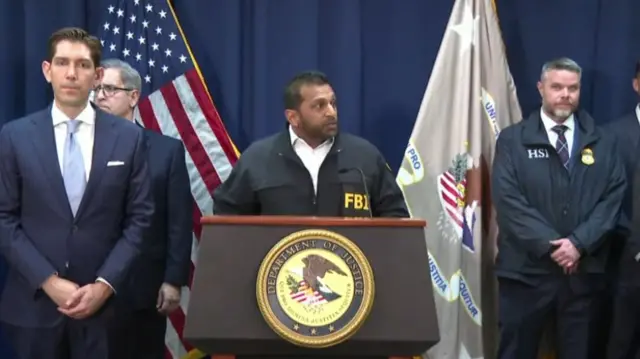 FBI director Kash Patel speaking behind a podium that says Department of Justice.
