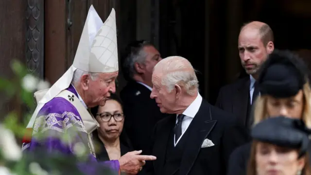 King Charles speaks with Cardinal Vincent Nichols, with Prince William in the background