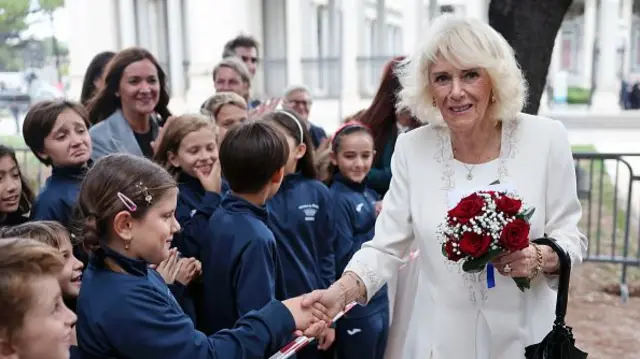Queen Camilla stops to talk to school children