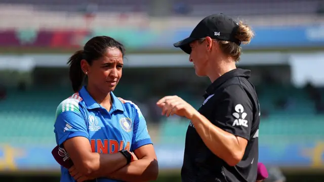 Harmanpreet Kaur of India (L) speaks to Sophie Devine of New Zealand