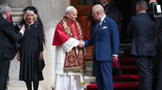 King and Pope shake hands in the courtyard of San Damaso, Vatican