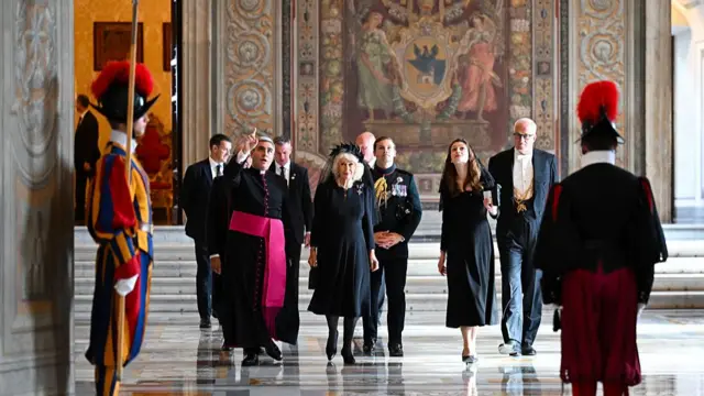Queen Camilla is during a visit to the Pauline Chapel. Someone next to her points upwards to show her something