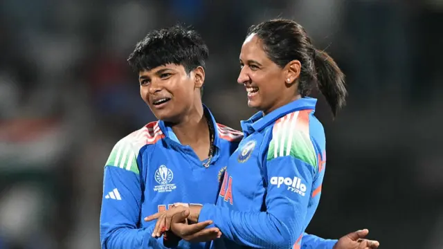 India's Kranti Goud (L) celebrates with captain Harmanpreet Kaur