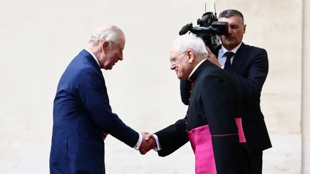 King Charles shakes the hand of Monsignor Leonardo Sapienza at the courtyard of San Damaso