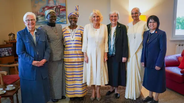 Queen Camilla stands in a line with some women
