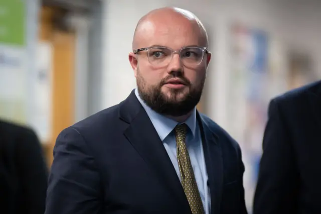 Llyr Powell wearing a suit with a tie