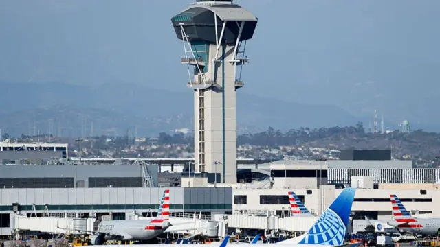 An air traffic control tower and airplanes at Los Angeles International Airport