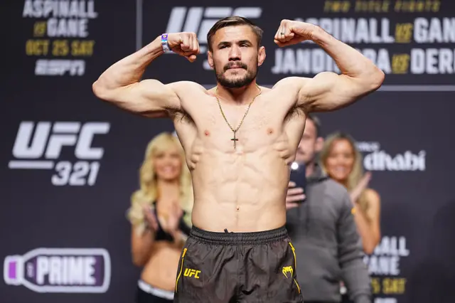 Nathaniel Wood holds up his arms as he weighs in for a UFC fight