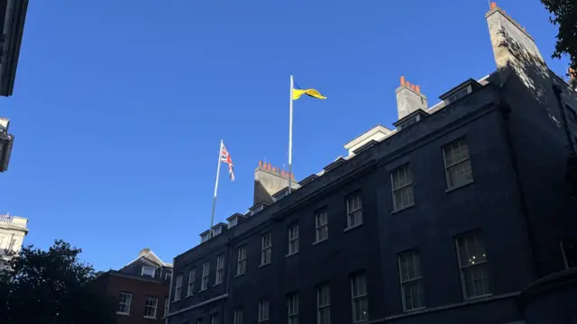 A view of Downing street showing the UK flag and Ukrainian flag atop a building