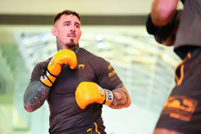 Tom Aspinall wearing orange boxing gloves