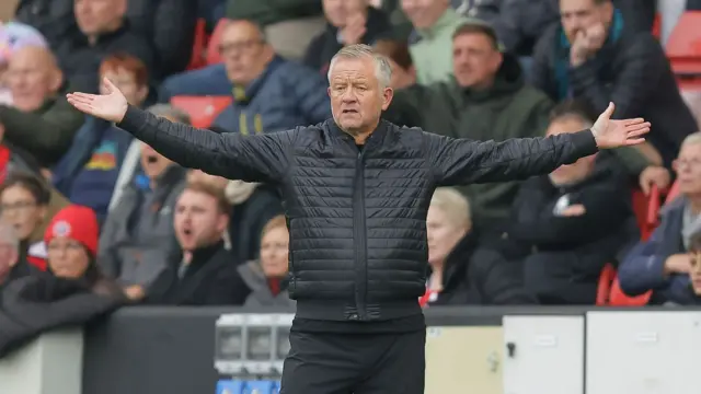 Chris WIlder with arms spread on the touchline
