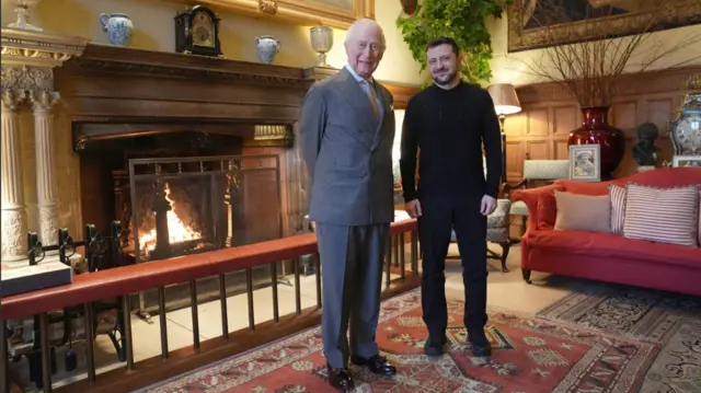 King Charles (L) poses next to Volodymyr Zelensky (R) inside a meeting room at Sandringham