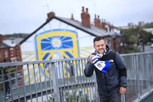 Leeds fan holding a Leeds scarf up