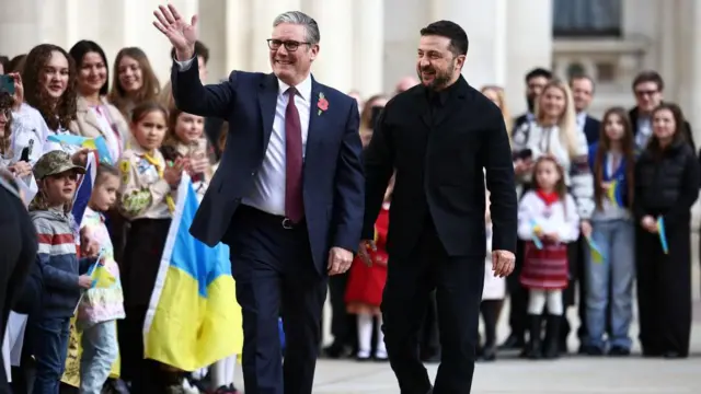 Keir Starmer waves at the crowd of supporters as Volodymyr Zelensky walks beside him