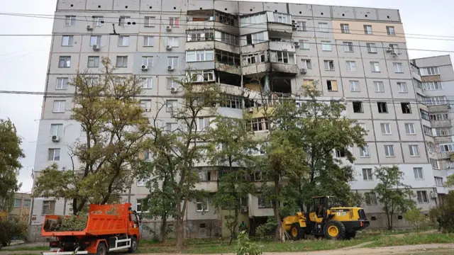 City utility workers clean up the aftermath of the Russian shelling on October 24, 2025 in Kherson, Ukraine