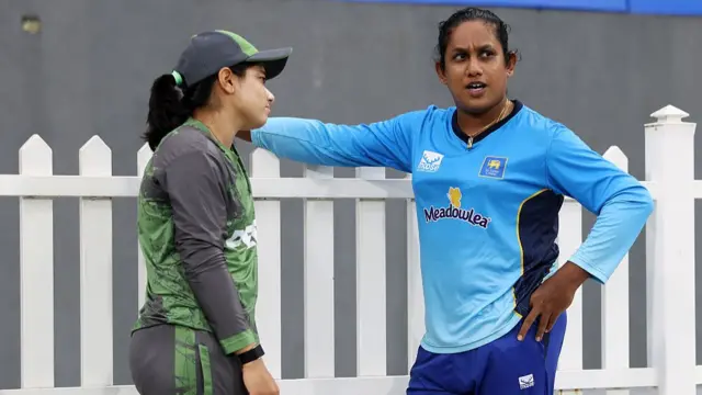 Chamari Athapaththu of Sri Lanka speaks to Fatima Sana of Pakistan as rain interrupts play