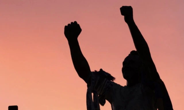 Leeds United fans pose for selfies in front of the Billy Bremner statue outside