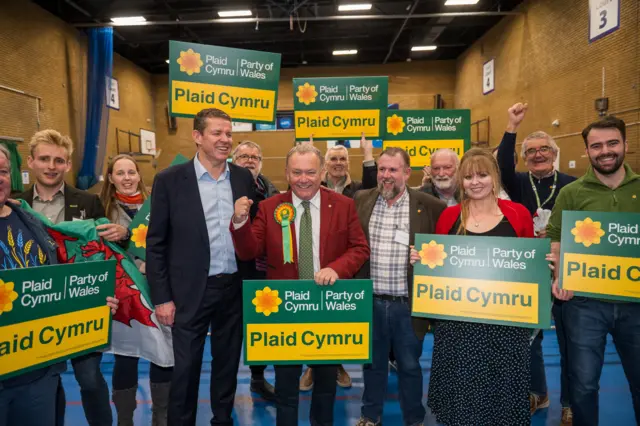 Lindsay Whittle, Rhun ap Iorwerth and Plaid Cymru supporters celebrate their victory