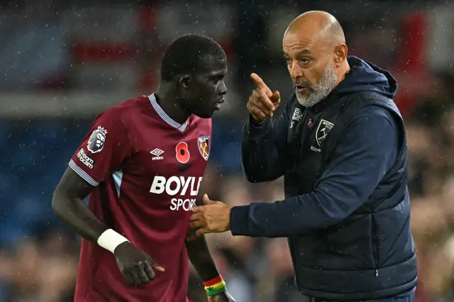 West Ham United's Portuguese head coach Nuno Espírito Santo (R) talks with West Ham United's Senegalise defender #12 El Hadji Malick Diouf