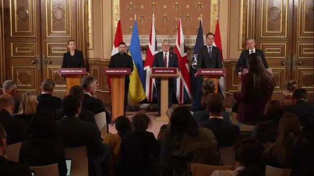 Five leaders standing in a line at a podium