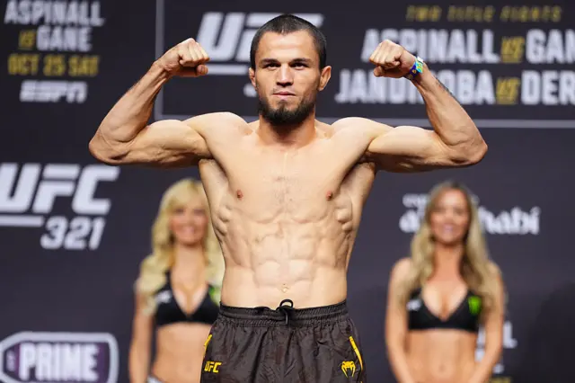 Umar Nurmagomedov holds up his arms as he weighs in for a UFC fight