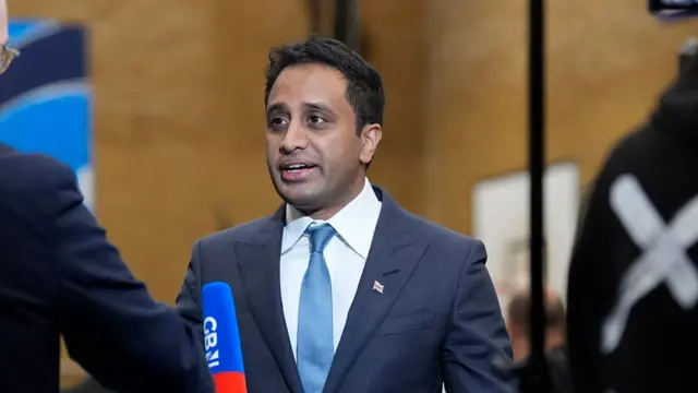 A man in a blue suit with a blue tie