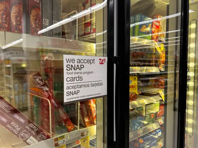 a sign on a Walgreens storefront window saying "we accept SNAP cards"