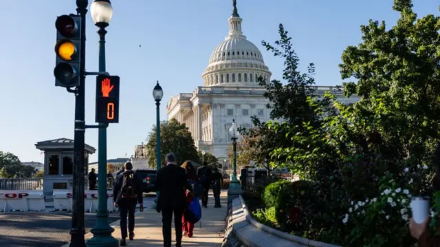 Pedestrians cross the street near the US Capitol