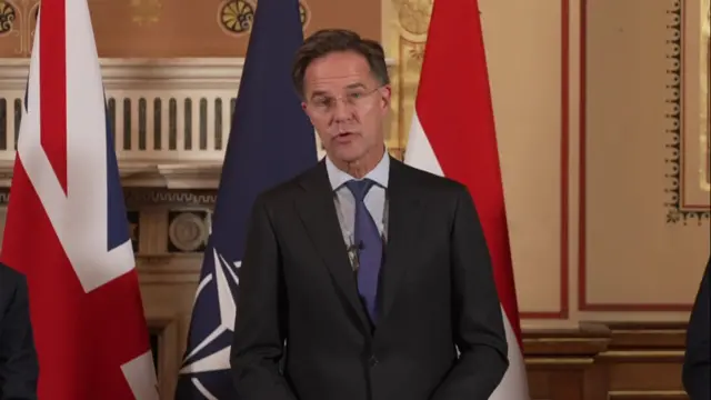 Rutte stands at a podium