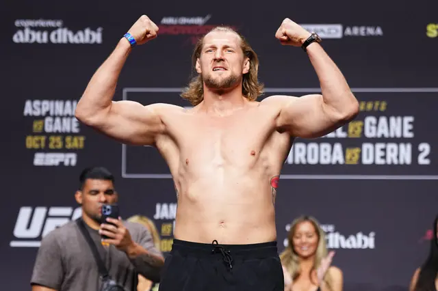 Alexander Volkov holds up his arms as he weighs in for a UFC fight