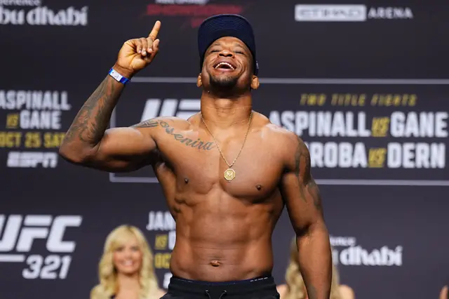 Jailton Almeida holds up his fists as he weighs in for a UFC fight