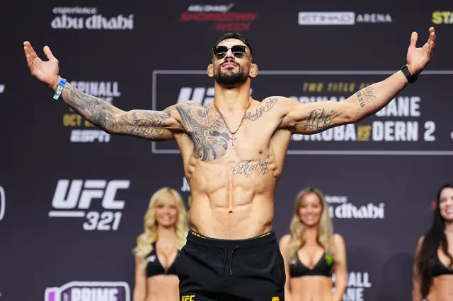 Aleksandar Rakic holds up his hand as he weighs in for a UFC fight