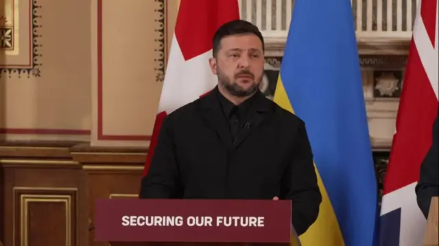 Zelensky stands at a podium